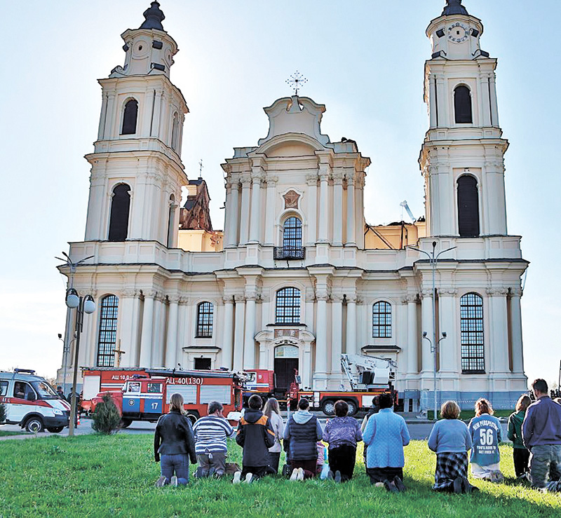 Po uratowaniu wszystkich możliwych rzeczy miejscowi wierni modlą się przed świątynią